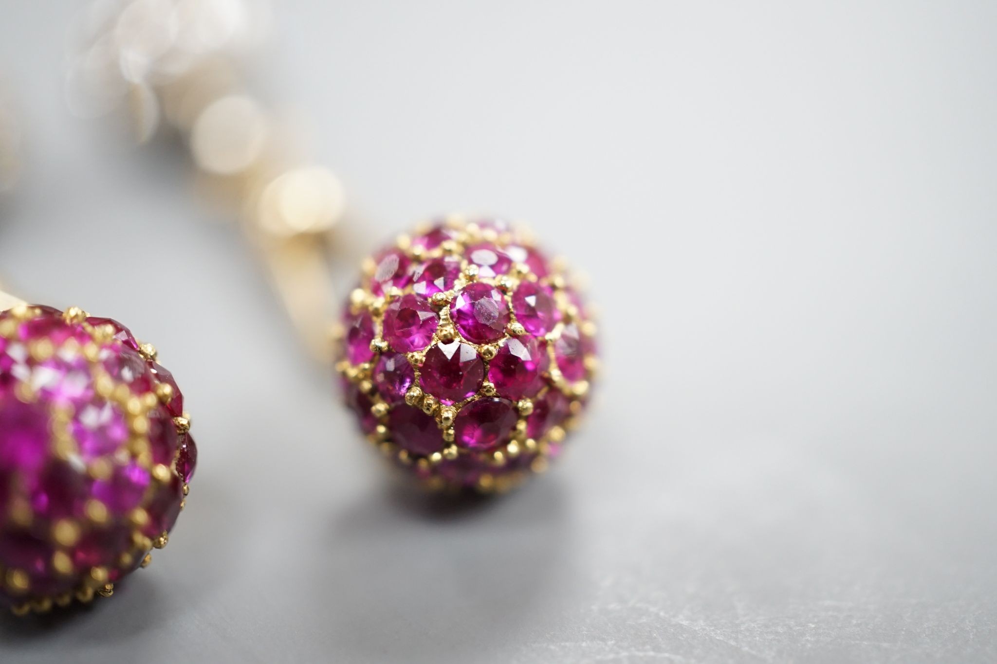 A pair of yellow metal and pave set ruby and diamond cufflinks (adapted), gross weight 10 grams.